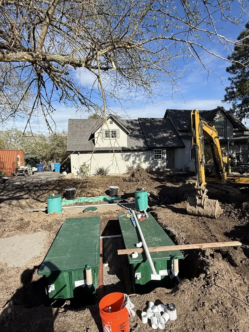 Septic tanks and lines open in the ground beside the home during installation