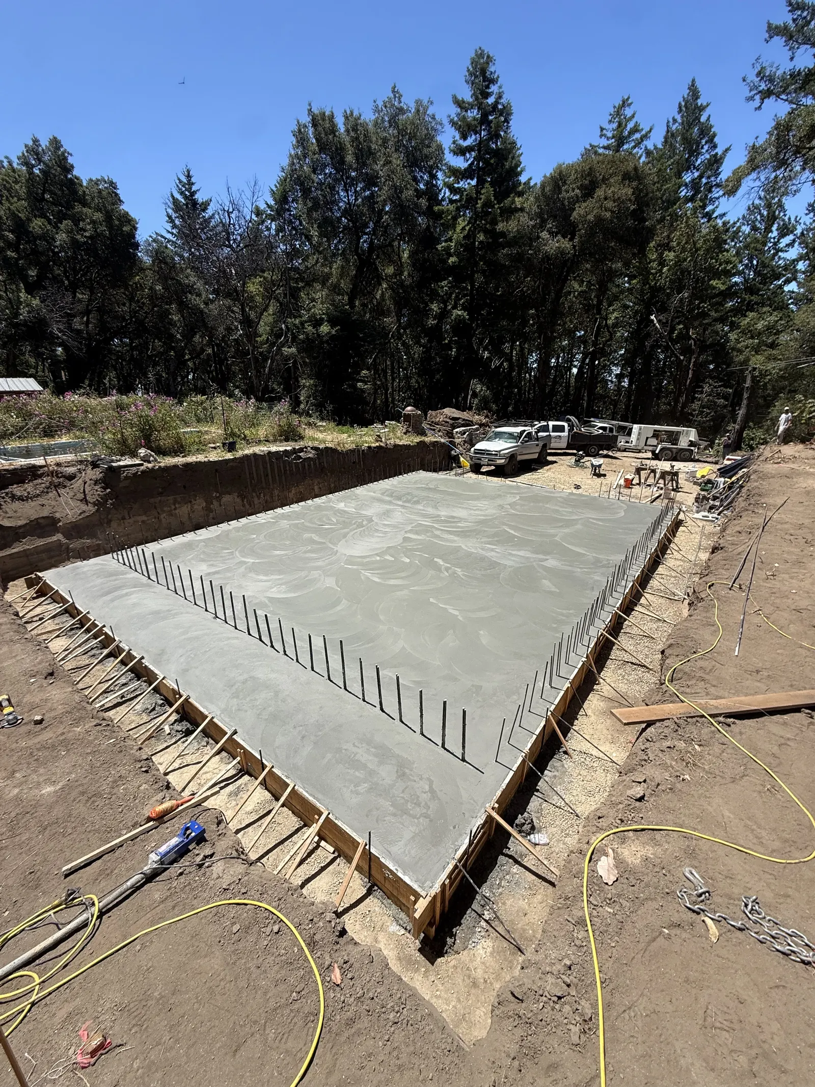 Freshly poured concrete foundation slab with formwork and rebar edges